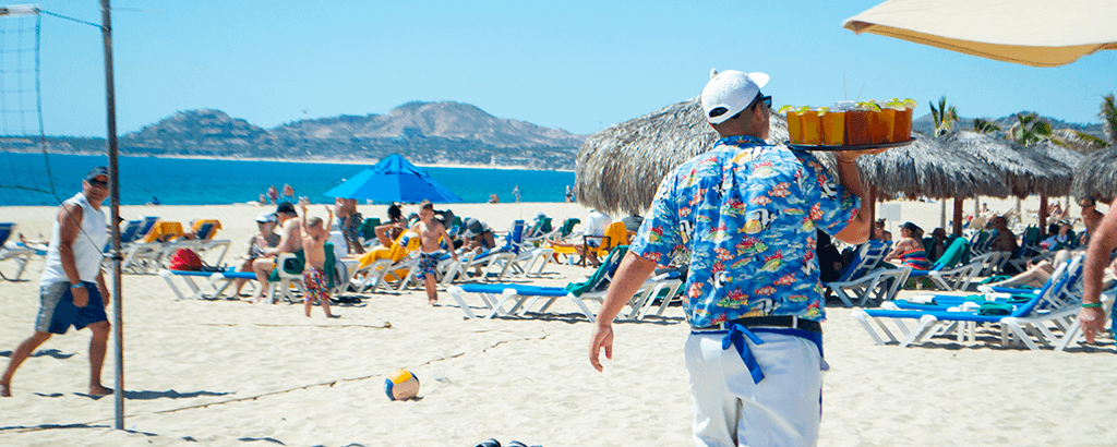 Mesero llevando bebidas en la playa de Royal Solaris Los Cabos